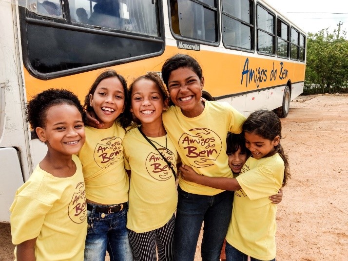 crianças sorrindo com camisetas do Amigo do Bem